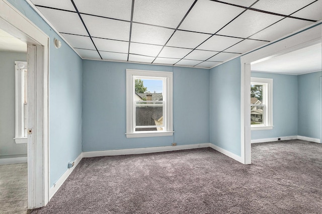 carpeted spare room with a paneled ceiling