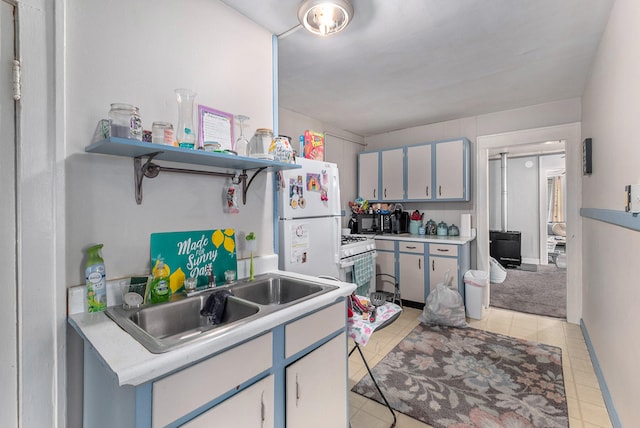 kitchen featuring white refrigerator, light tile patterned floors, and sink