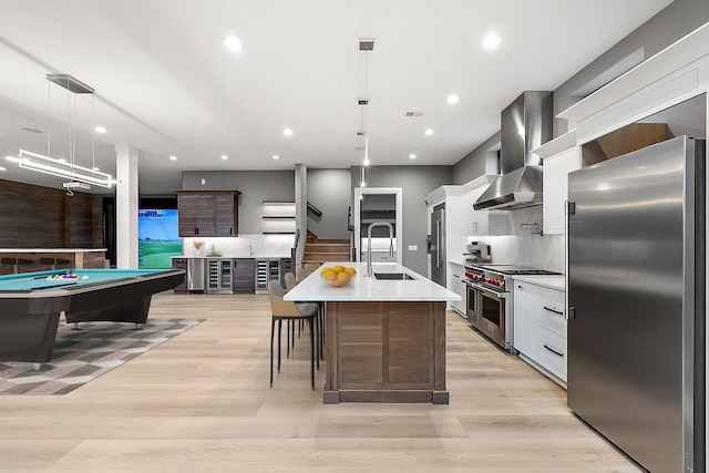 1535 Vista Dr, Oakland, MI 48363 - kitchen with sink, wall chimney exhaust hood, an island with sink, decorative light fixtures, and appliances with stainless steel finishes