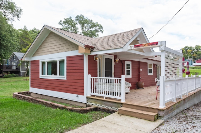 back of house featuring a lawn and a deck