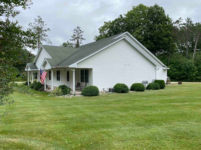 view of home's exterior with a yard, central AC unit, and a porch