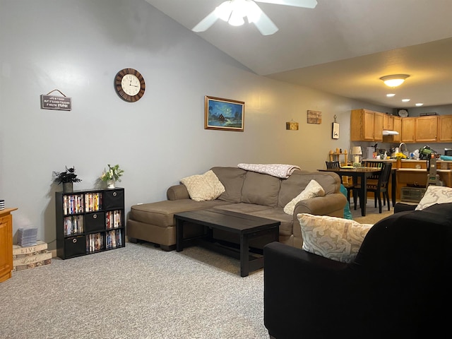 living room featuring ceiling fan, light carpet, and vaulted ceiling