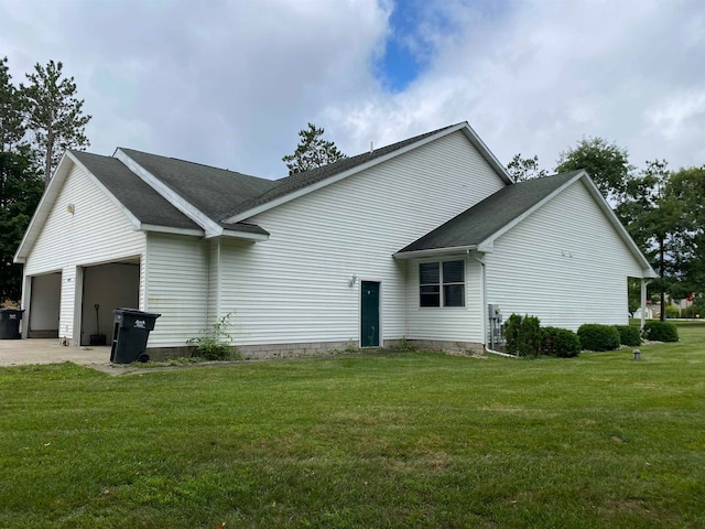 back of house featuring a yard and a garage