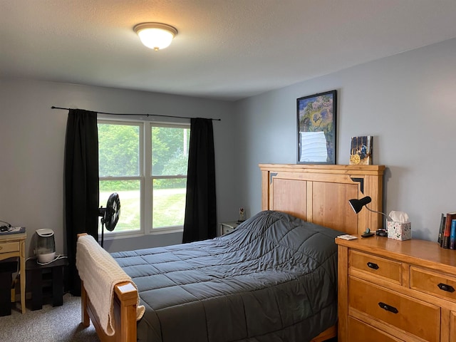 carpeted bedroom featuring a textured ceiling and multiple windows