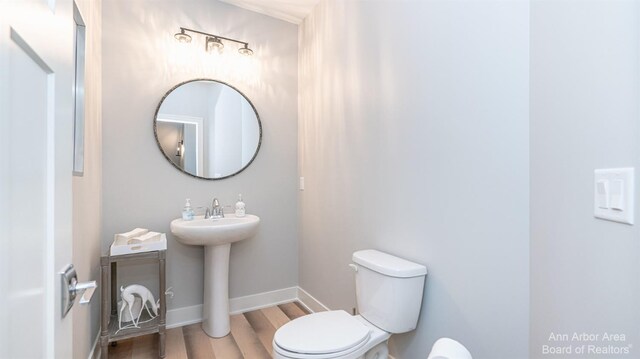 46 Gallery Pointe Dr, Saline, MI 48176 - half bathroom featuring wood finished floors, toilet, a sink, and baseboards