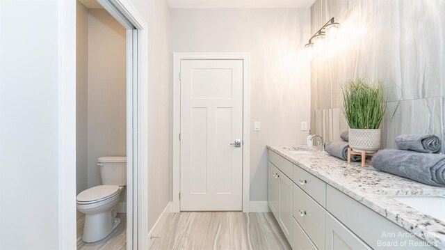 46 Gallery Pointe Dr, Saline, MI 48176 - full bathroom featuring double vanity, toilet, and baseboards