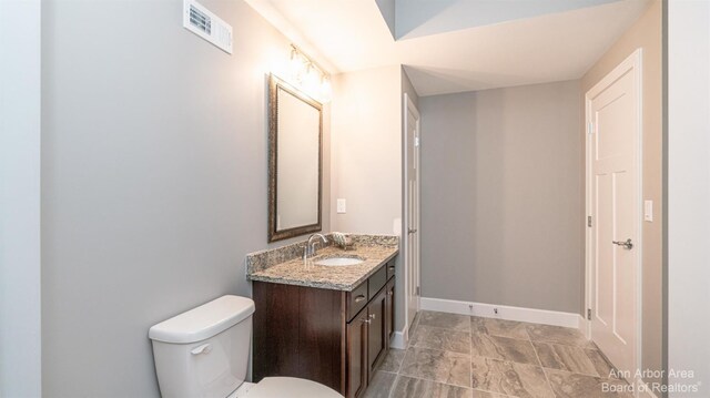 46 Gallery Pointe Dr, Saline, MI 48176 - bathroom with vanity, toilet, baseboards, and stone finish flooring