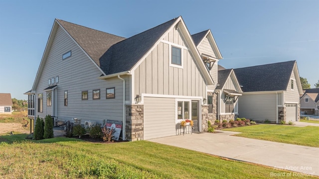 46 Gallery Pointe Dr, Saline, MI 48176 - view of side of property with board and batten siding, stone siding, a lawn, and roof with shingles
