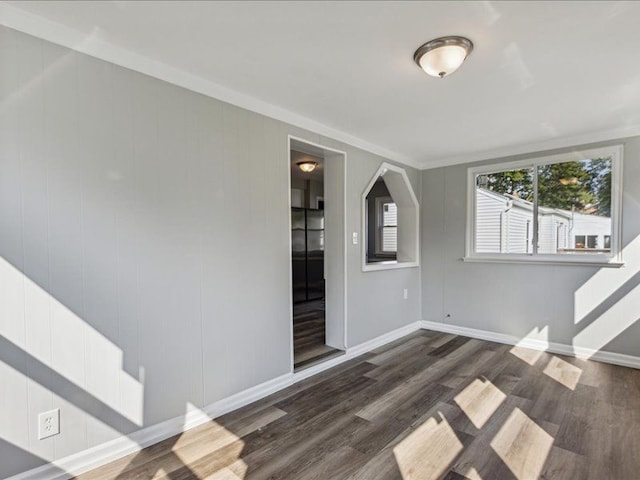 spare room with crown molding and dark hardwood / wood-style flooring