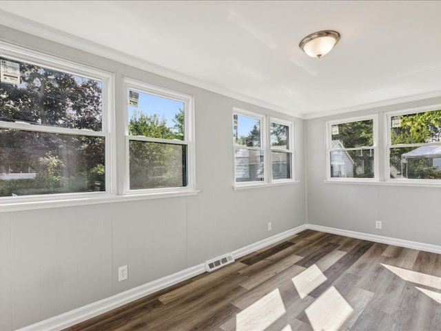 unfurnished room featuring crown molding and hardwood / wood-style floors