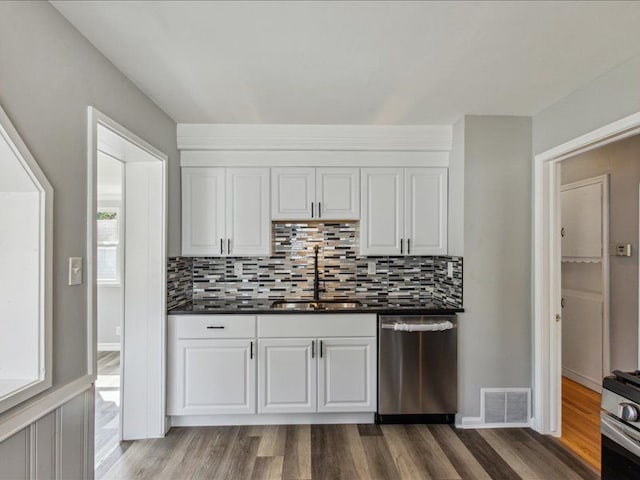 kitchen featuring white cabinetry, sink, stainless steel appliances, backsplash, and wood-type flooring