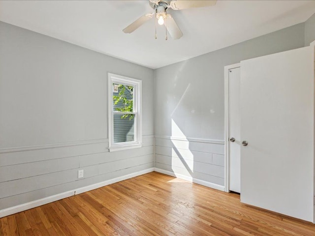 spare room with ceiling fan and light wood-type flooring