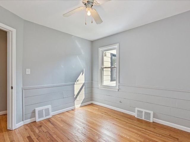 empty room with ceiling fan and light hardwood / wood-style flooring