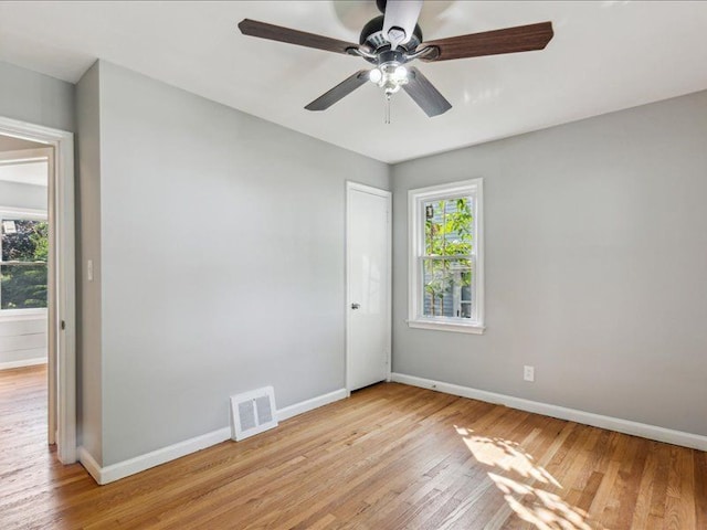 spare room featuring ceiling fan, a healthy amount of sunlight, and light wood-type flooring