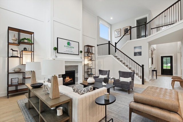 living room featuring a healthy amount of sunlight, light hardwood / wood-style floors, and a high ceiling