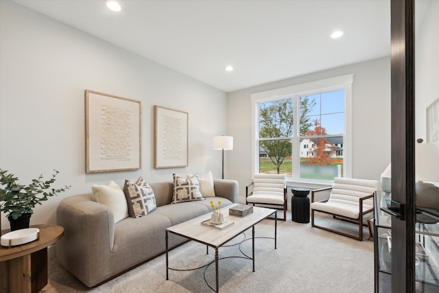 carpeted living room with a water view