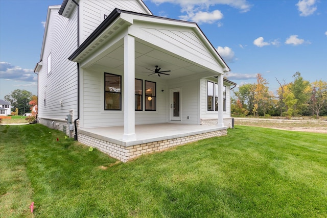 back of property featuring ceiling fan, a yard, and a patio