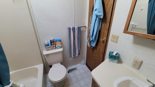 bathroom with a tub to relax in, vanity, and toilet