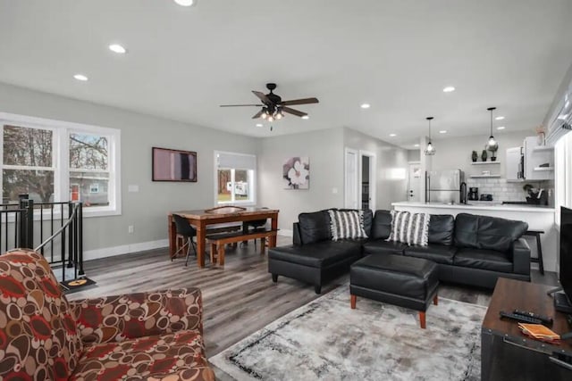 living room featuring ceiling fan and light hardwood / wood-style flooring