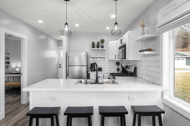 kitchen with sink, white cabinets, stainless steel appliances, and plenty of natural light