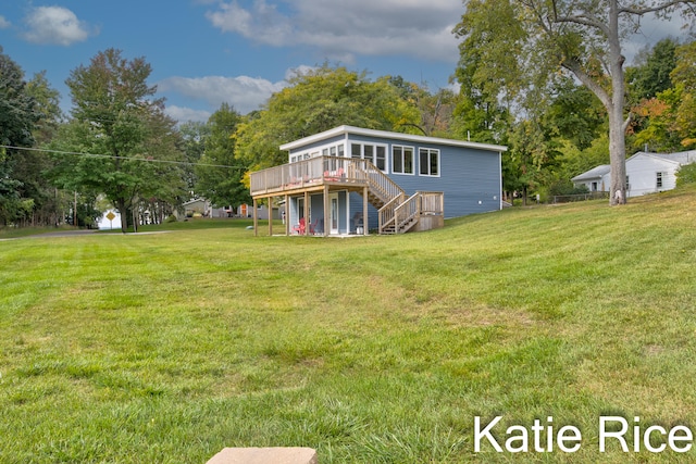 rear view of property featuring a yard and a wooden deck