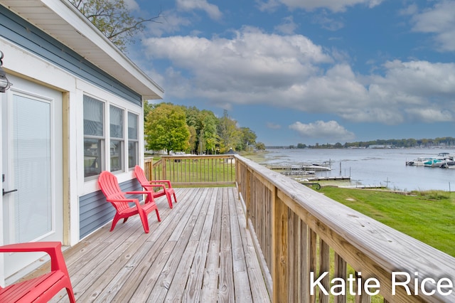 wooden terrace featuring a lawn and a water view