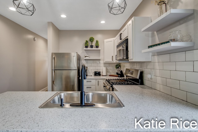 kitchen featuring tasteful backsplash, light stone counters, stainless steel appliances, pendant lighting, and white cabinets