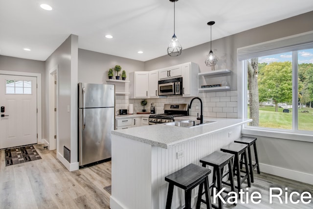 kitchen featuring sink, white cabinetry, stainless steel appliances, and a wealth of natural light