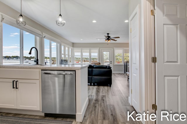 kitchen with dishwasher, light hardwood / wood-style floors, white cabinetry, and decorative light fixtures