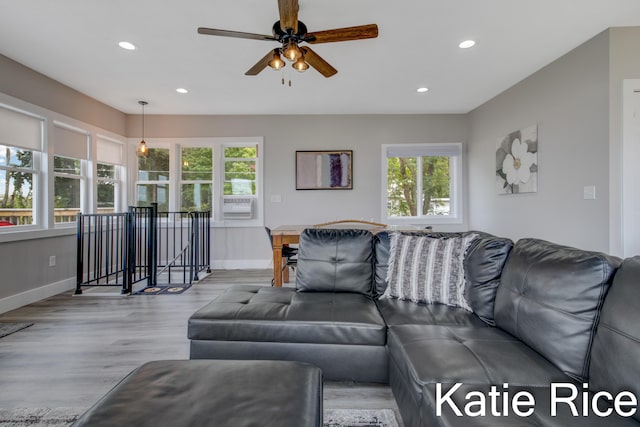 living room with ceiling fan and light hardwood / wood-style flooring