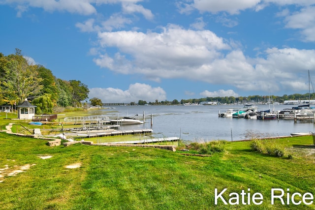 dock area featuring a lawn and a water view