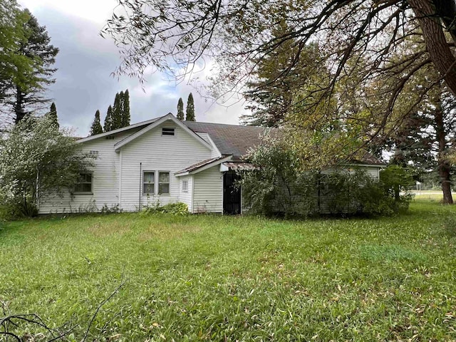 rear view of property featuring a yard