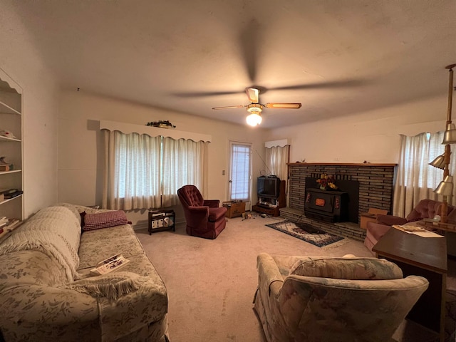 carpeted living room with ceiling fan and a wood stove