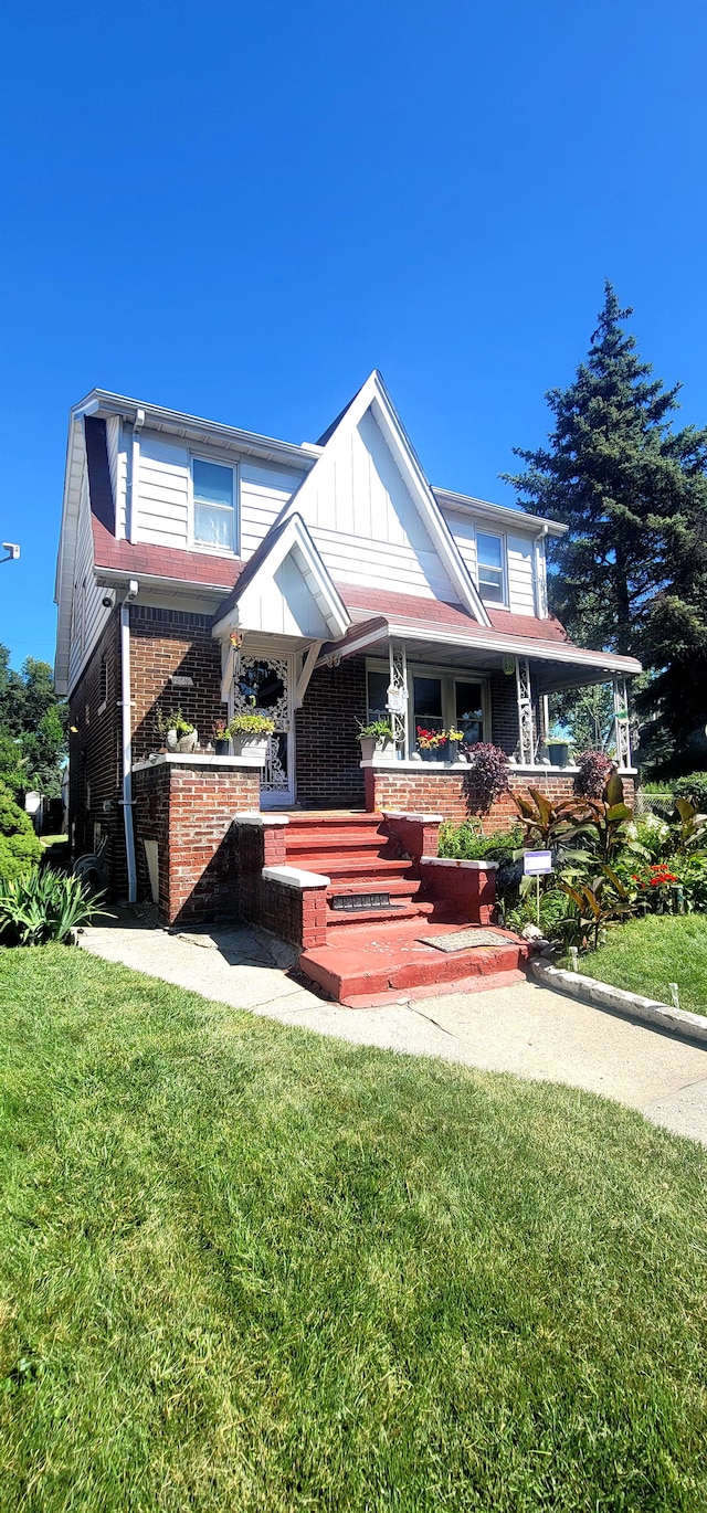 view of front of house with covered porch and a front lawn