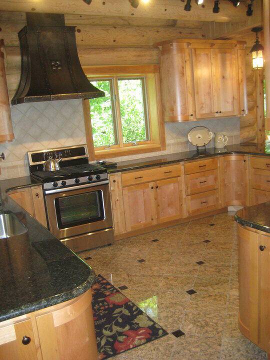 W4231 Wildwood Ln, Moran, MI 49760 - kitchen featuring stainless steel range with gas stovetop, custom range hood, light brown cabinetry, and backsplash