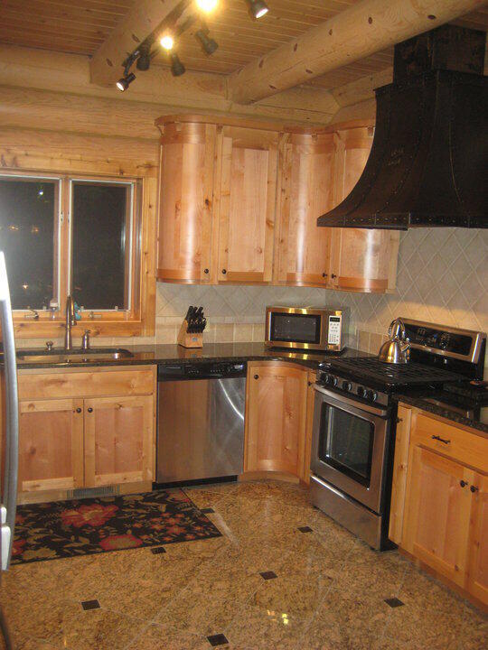 W4231 Wildwood Ln, Moran, MI 49760 - kitchen with stainless steel appliances, wood ceiling with exposed beams, custom range hood, light brown cabinets, and a sink