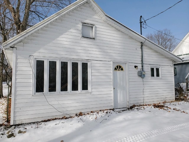 view of snow covered back of property