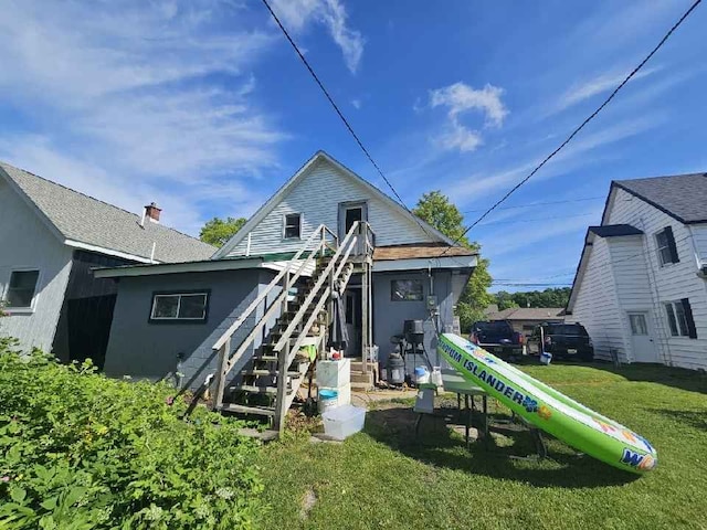 rear view of property featuring a lawn