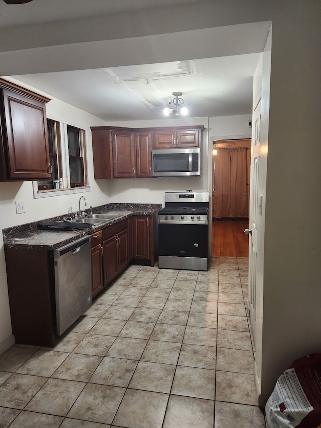 kitchen featuring light tile patterned flooring, appliances with stainless steel finishes, and sink