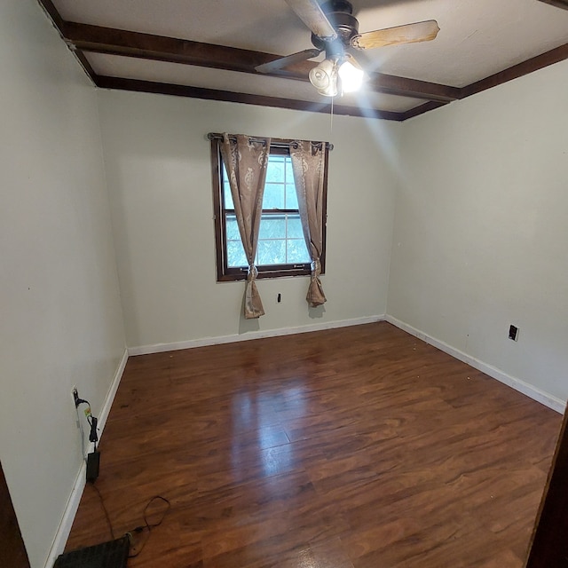 spare room with ceiling fan, beamed ceiling, and dark wood-type flooring