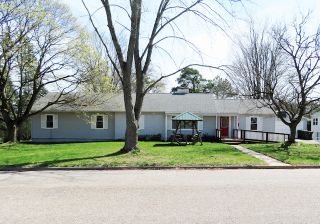 single story home featuring a front yard and a wooden deck