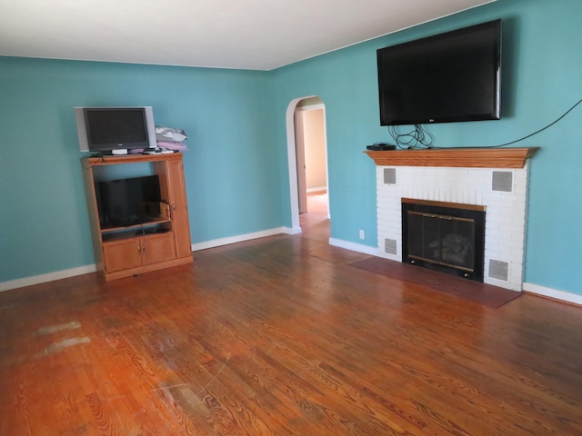 unfurnished living room featuring a fireplace and wood-type flooring