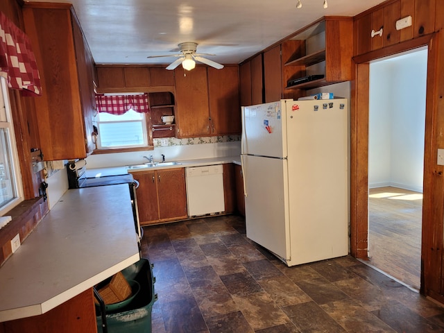 kitchen with ceiling fan, white appliances, sink, and kitchen peninsula