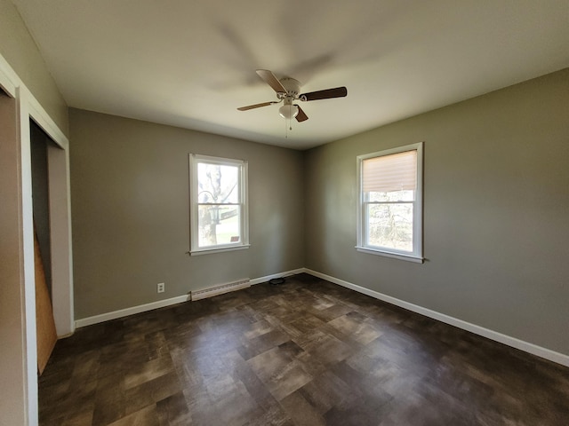 unfurnished bedroom with a closet, baseboard heating, and ceiling fan