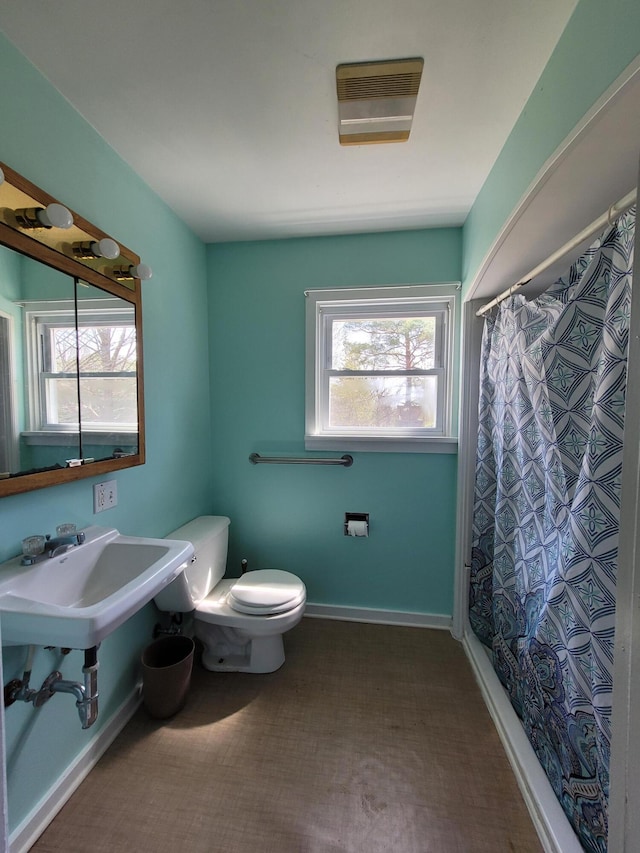 bathroom featuring a shower with shower curtain and toilet