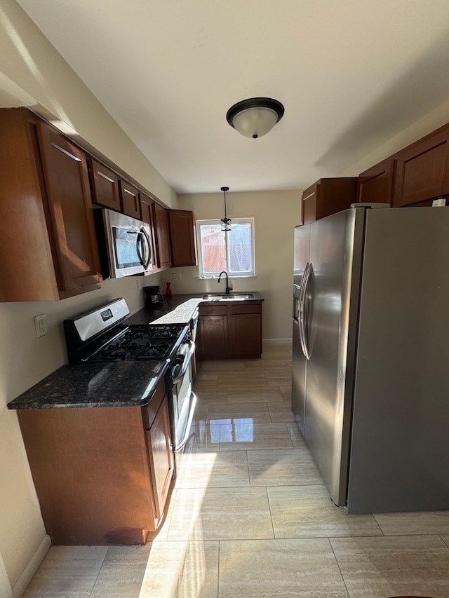 kitchen featuring dark stone countertops, sink, pendant lighting, and appliances with stainless steel finishes