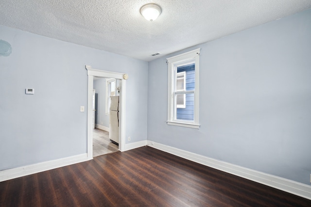 unfurnished room featuring a textured ceiling and hardwood / wood-style flooring