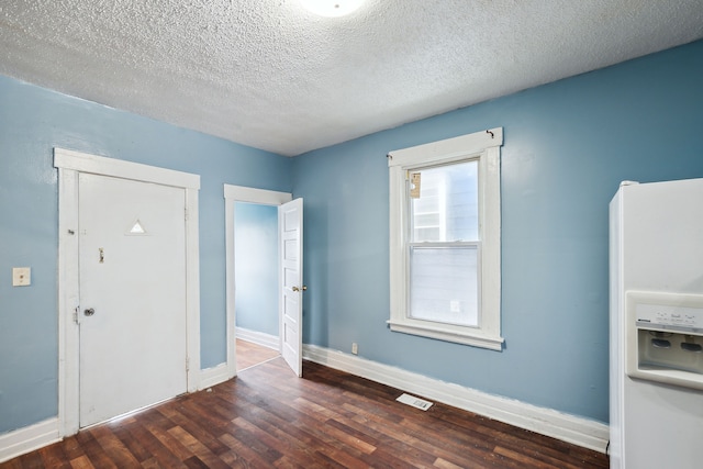 entryway featuring a textured ceiling and dark wood-type flooring