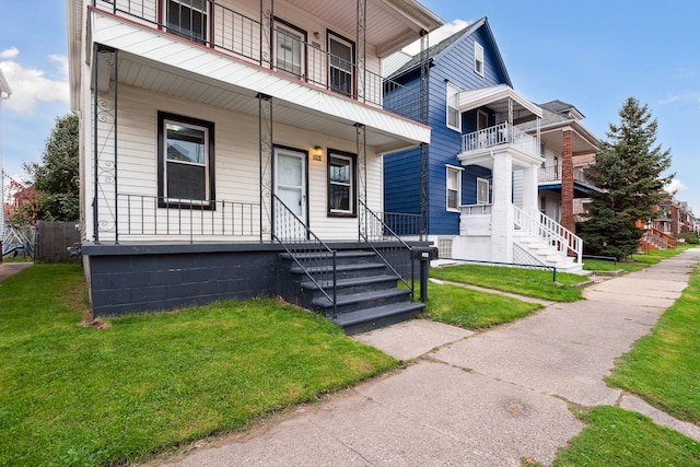 view of front of house featuring covered porch and a front yard