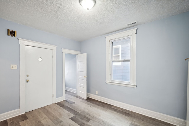 foyer entrance with a textured ceiling and hardwood / wood-style flooring